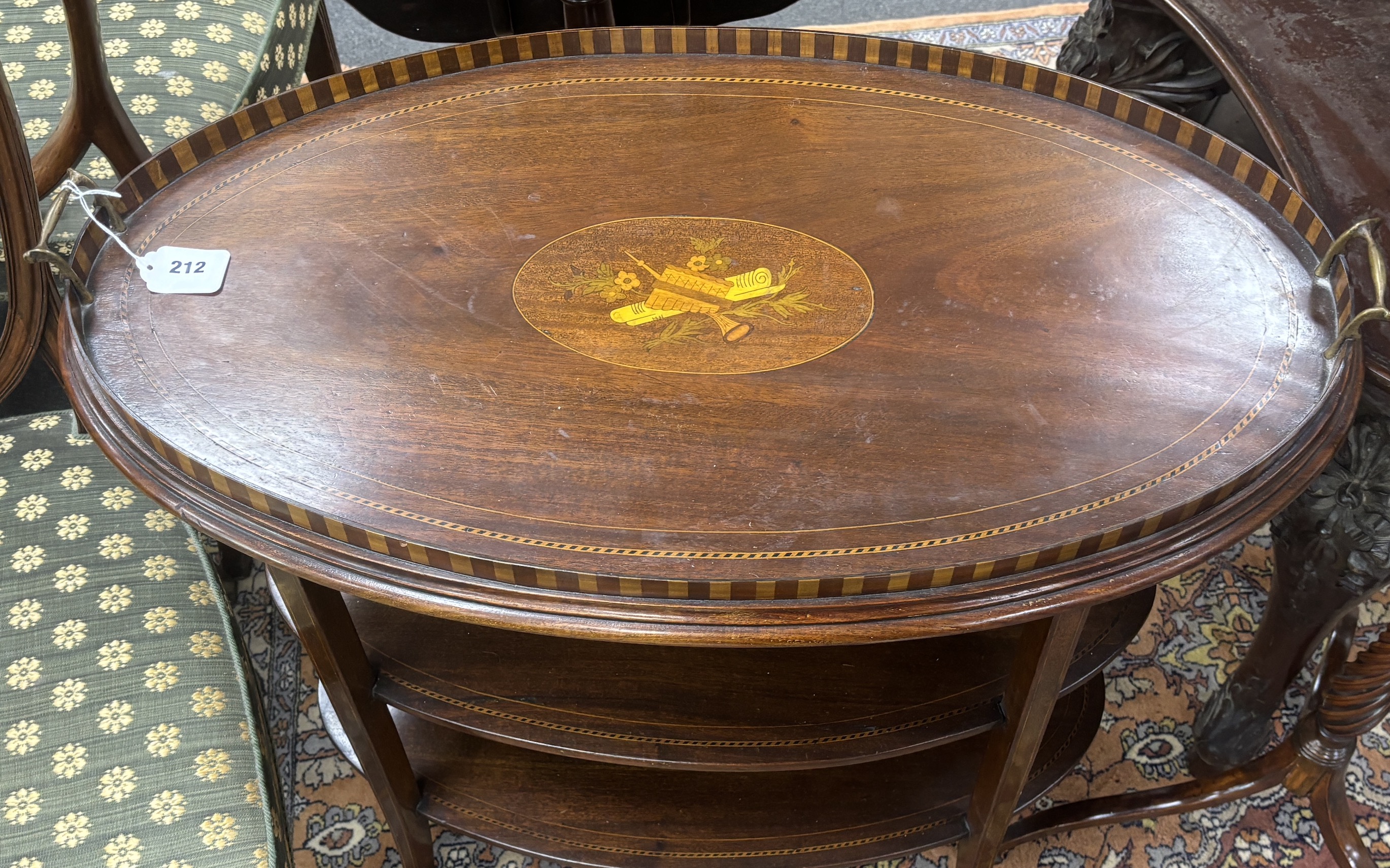 An Edwardian oval inlaid mahogany three tier etagere with removable tray top, width 80cm, depth 46cm, height 76cm